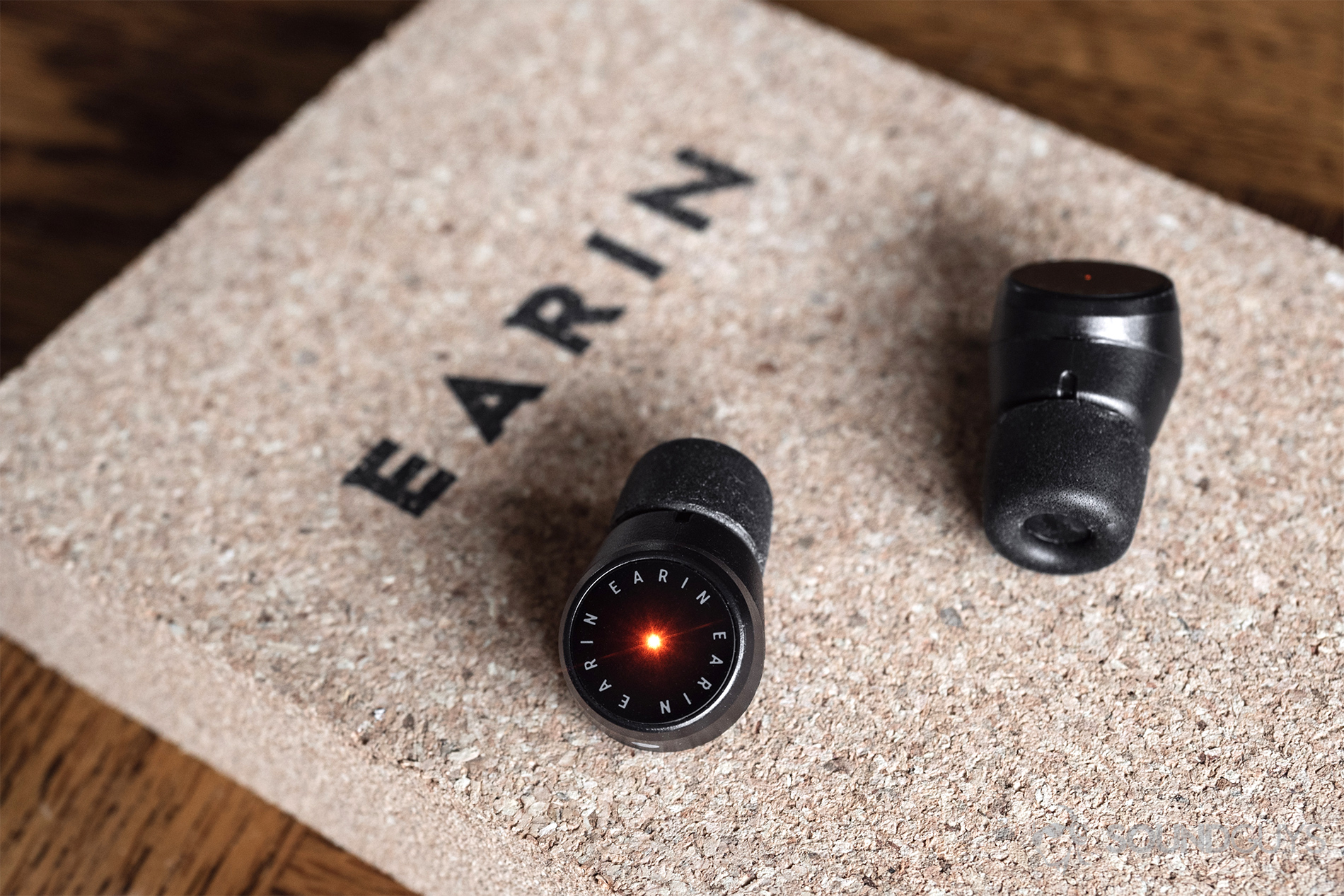 Earin M-2 review: One of the earbuds is flashing red on the flat, glossy touch panel.