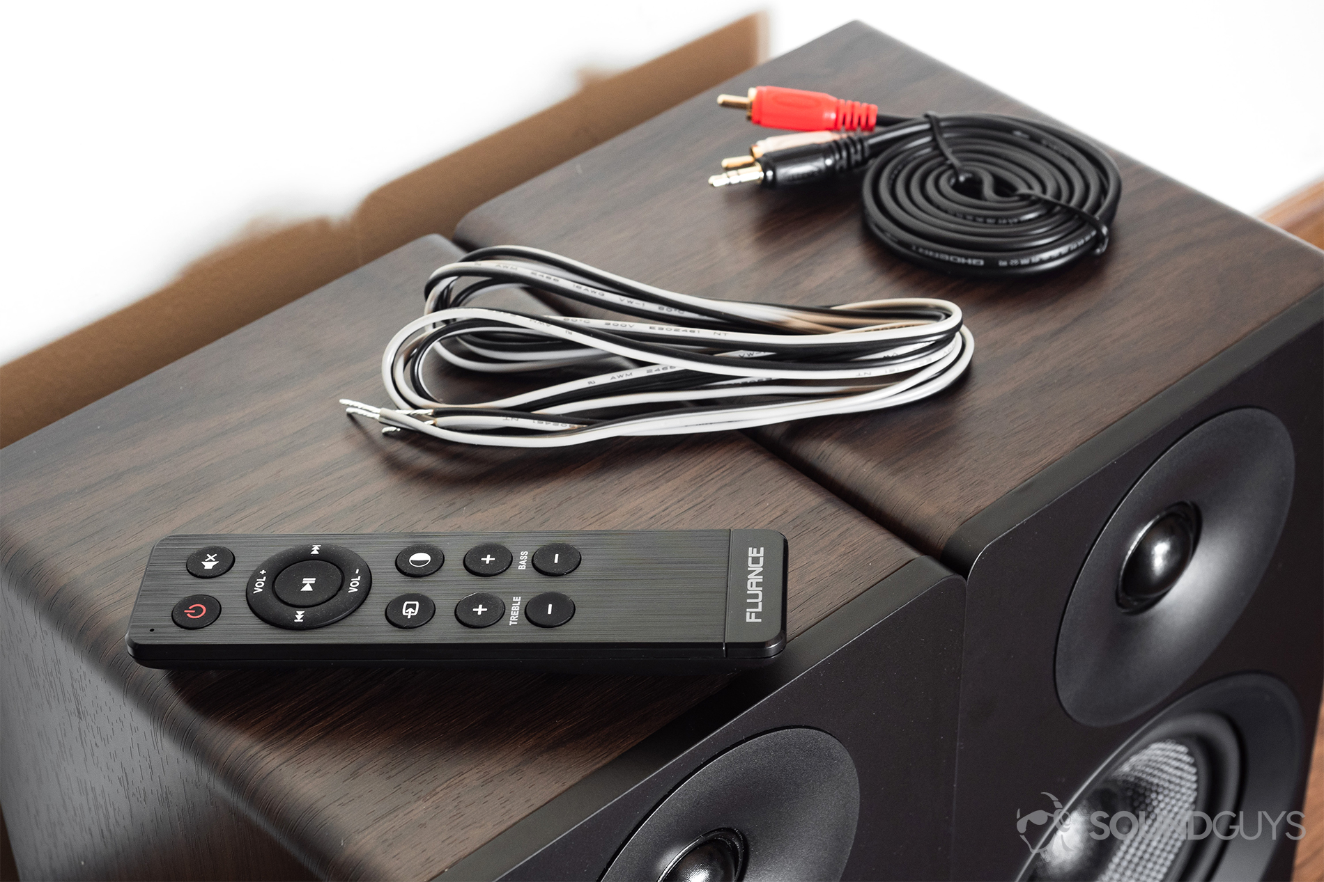 Fluance Ai40 review: The remote, adapter wire, and RCA cable all shown on top of the speaker units.