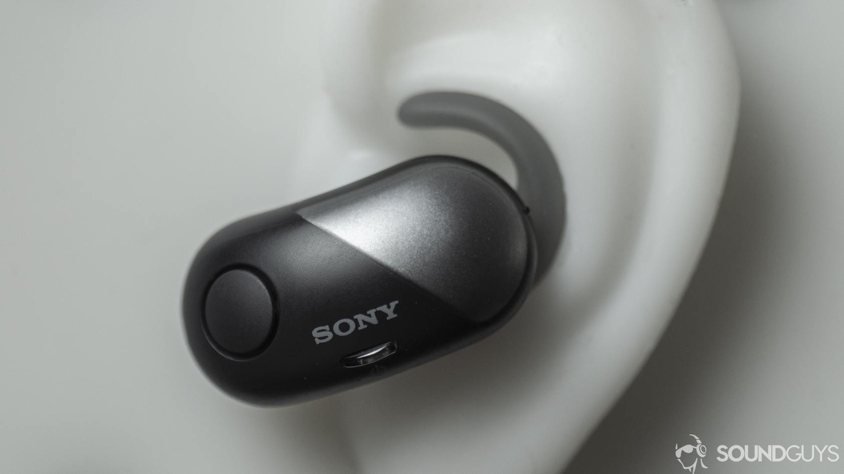 A photo of the Sony WF-SP700N true wireless earbuds in a silicon ear.