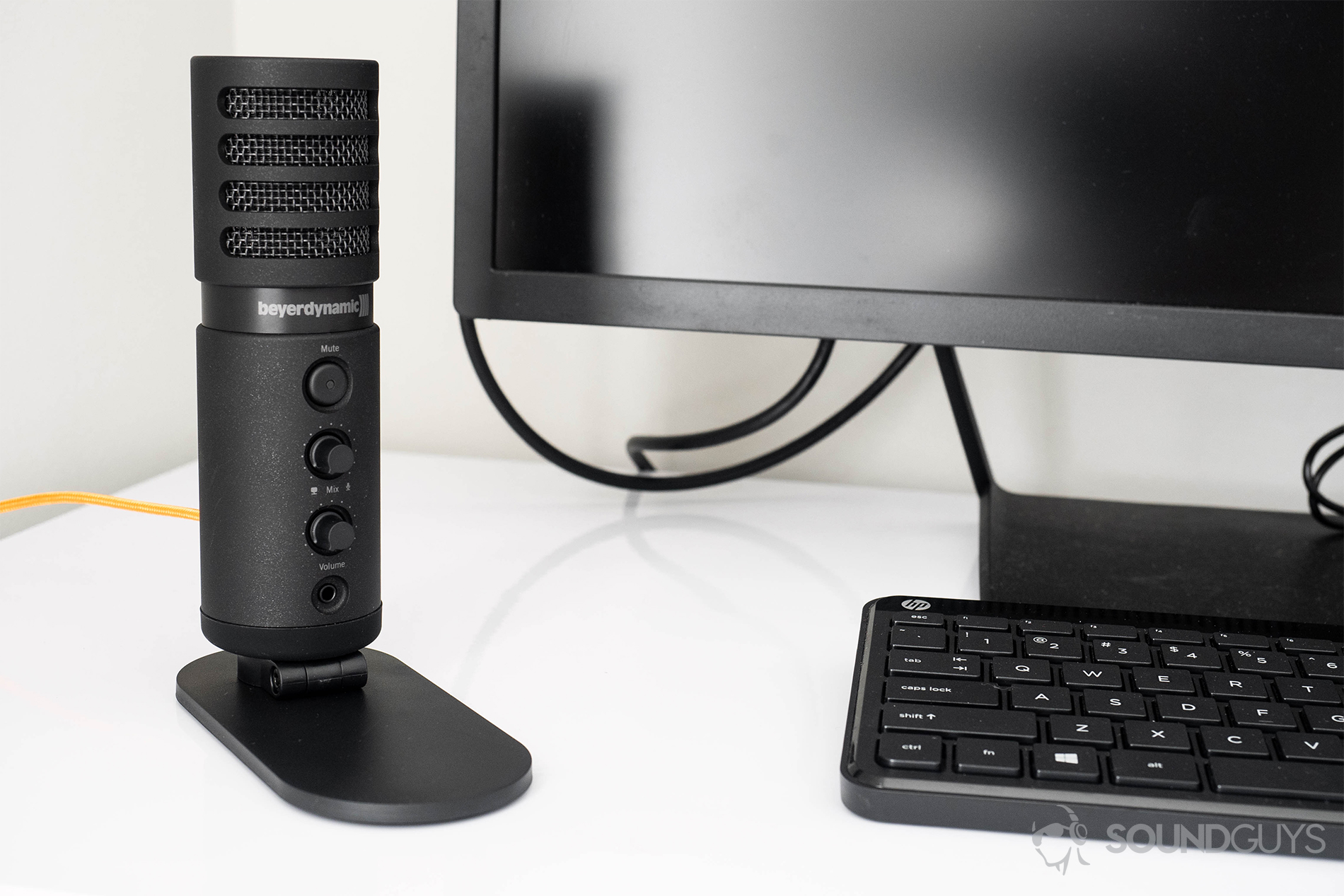 Beyerdynamic Fox USB microphone: A straight-on shot of the mic mounted and on a desk with a black monitor and keyboard.
