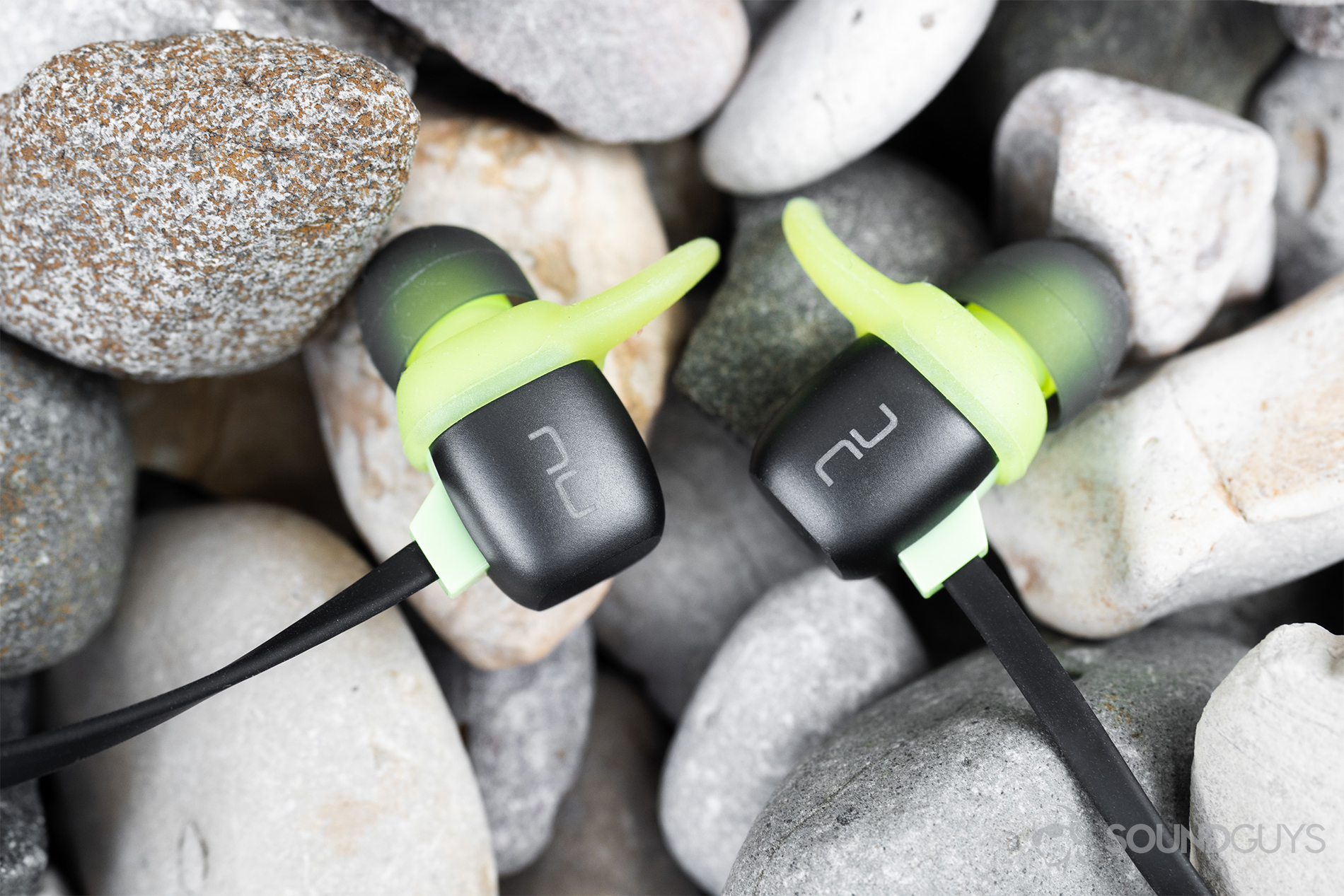 Optoma NuForce Be Sport4: The earbuds (close up) on a bed of rocks.