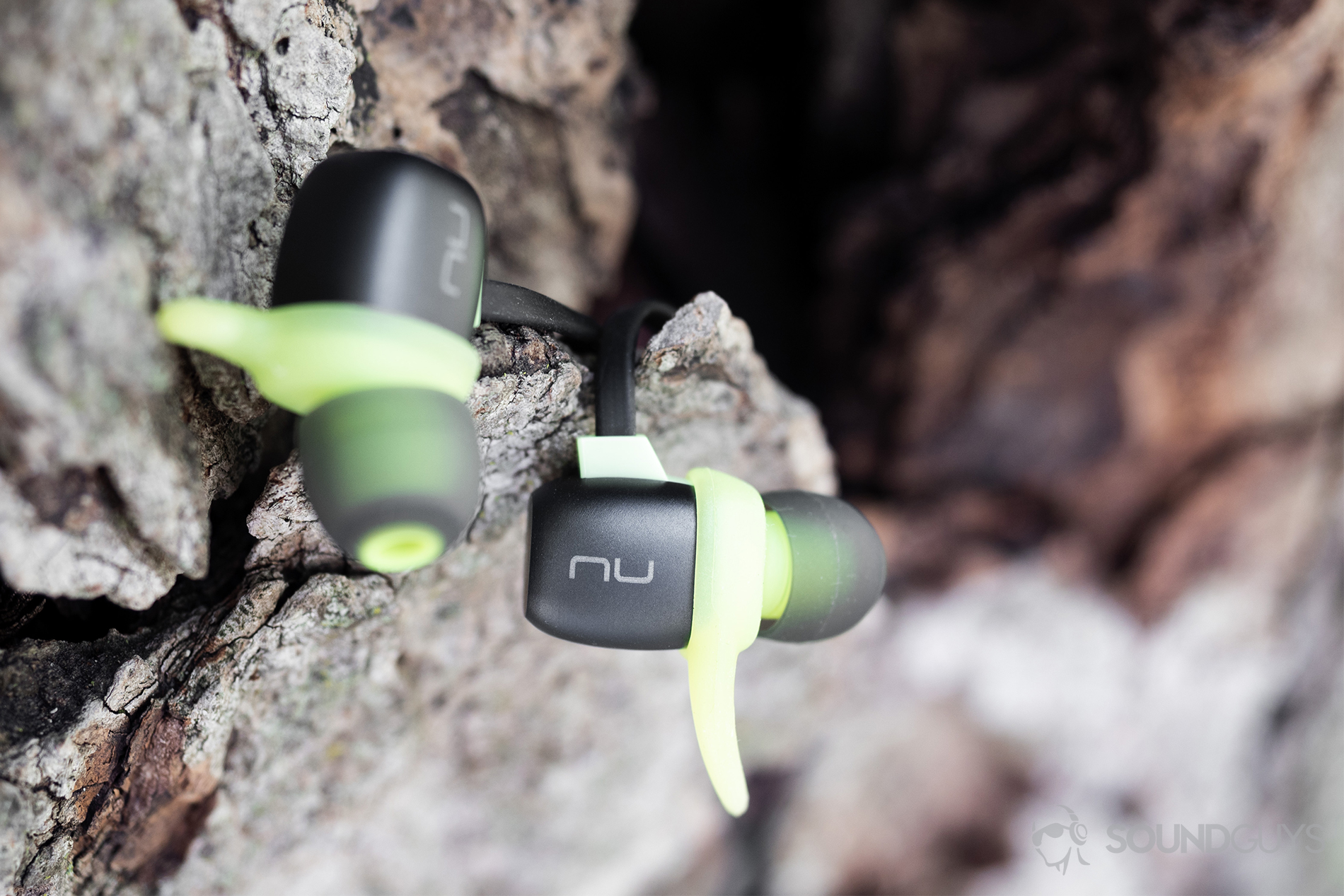 Optoma NuForce_Be Sport4-18 Optoma NuForce Be Sport4: The earbuds resting on broken bark of a tree.