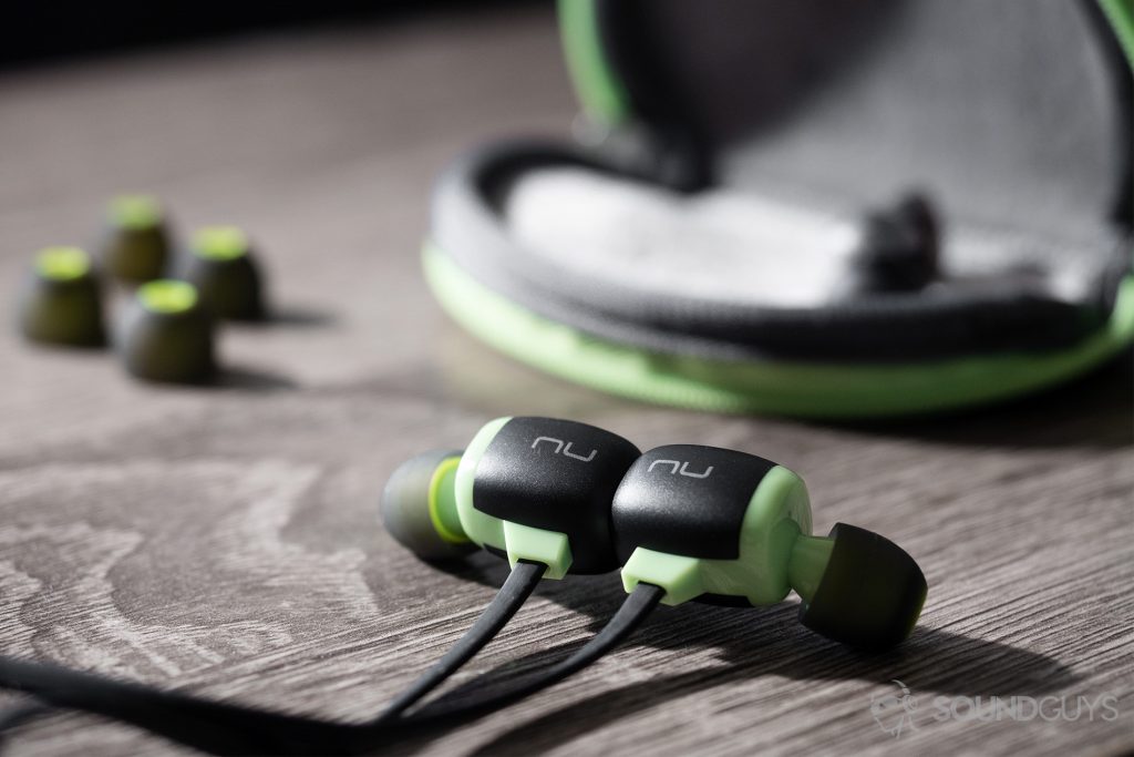 Optoma NuForce Be Sport4: An image of the earbuds connected via magnetic housing with the carrying case and a few ear tips in the back.
