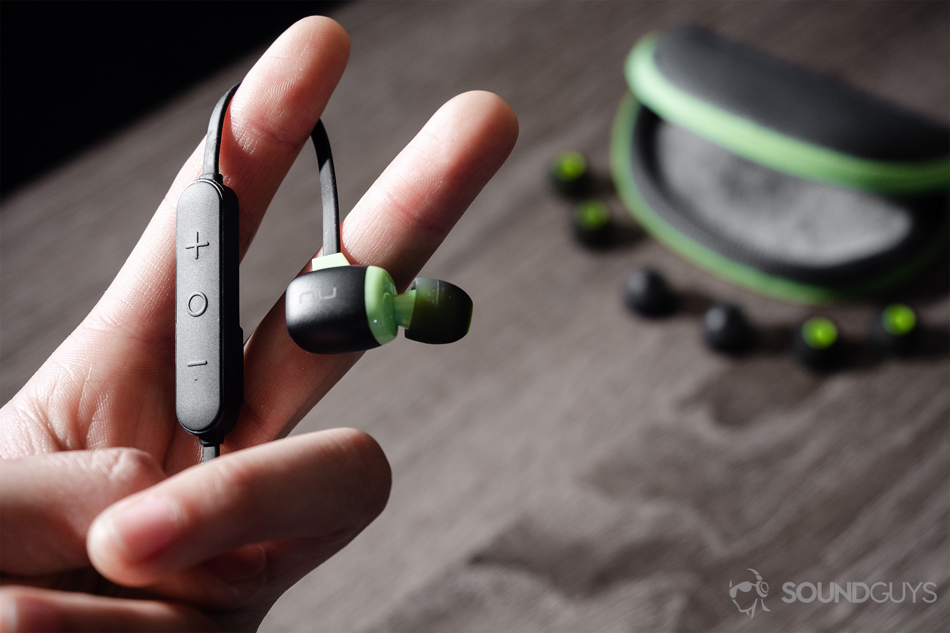 Optoma NuForce Be Sport4: The earbuds in the hand with the spare ear tips and carrying case in the background.
