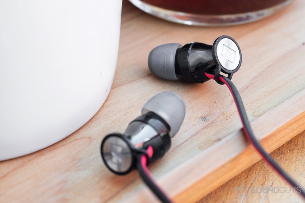 Sennheiser HD1 In-Ear Wireless: An image of the earbuds on a wooden tray with a coffee mug and holder on it.