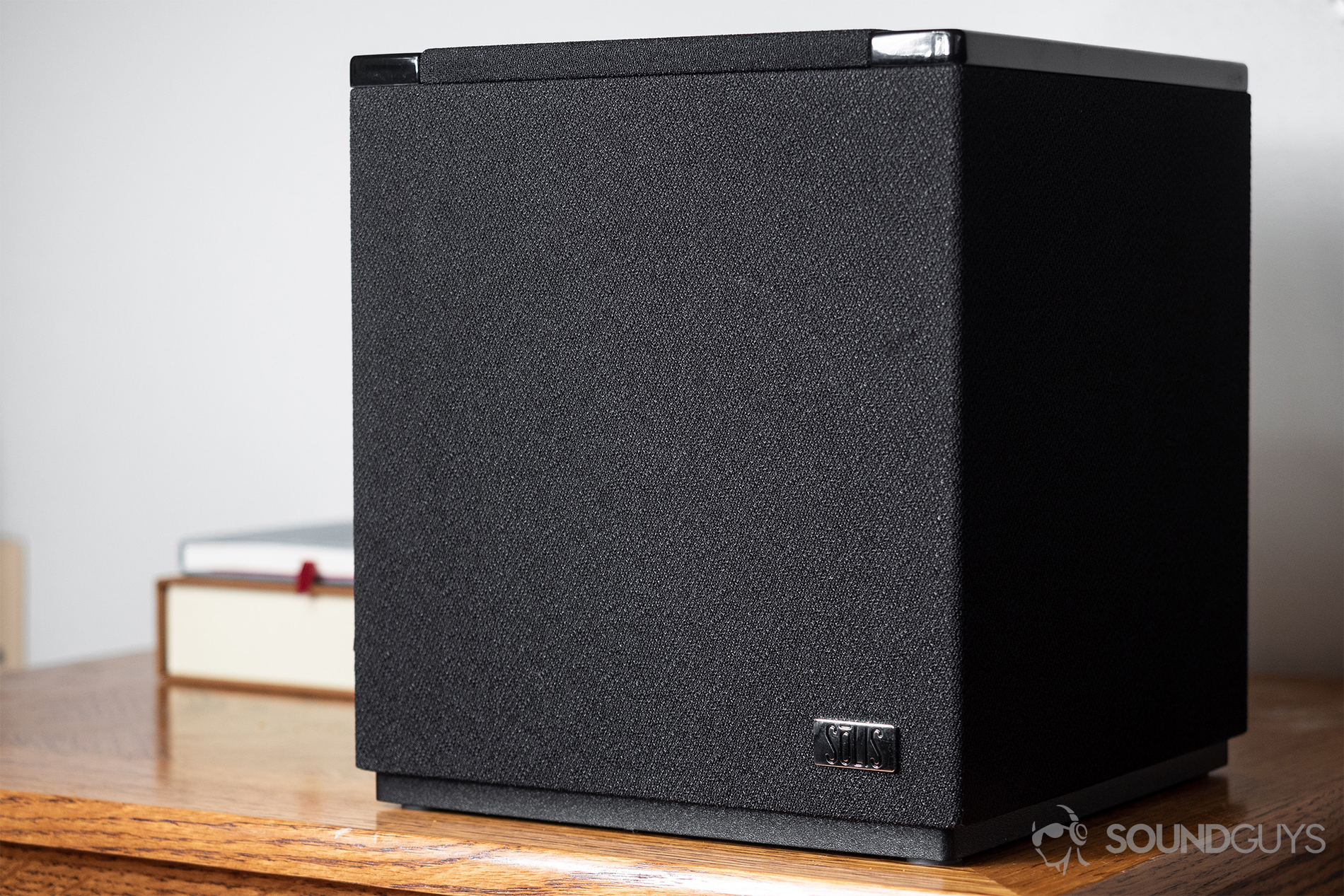 Solis SO-7000 review: Speaker on a wooden table with two stacked books in the background.