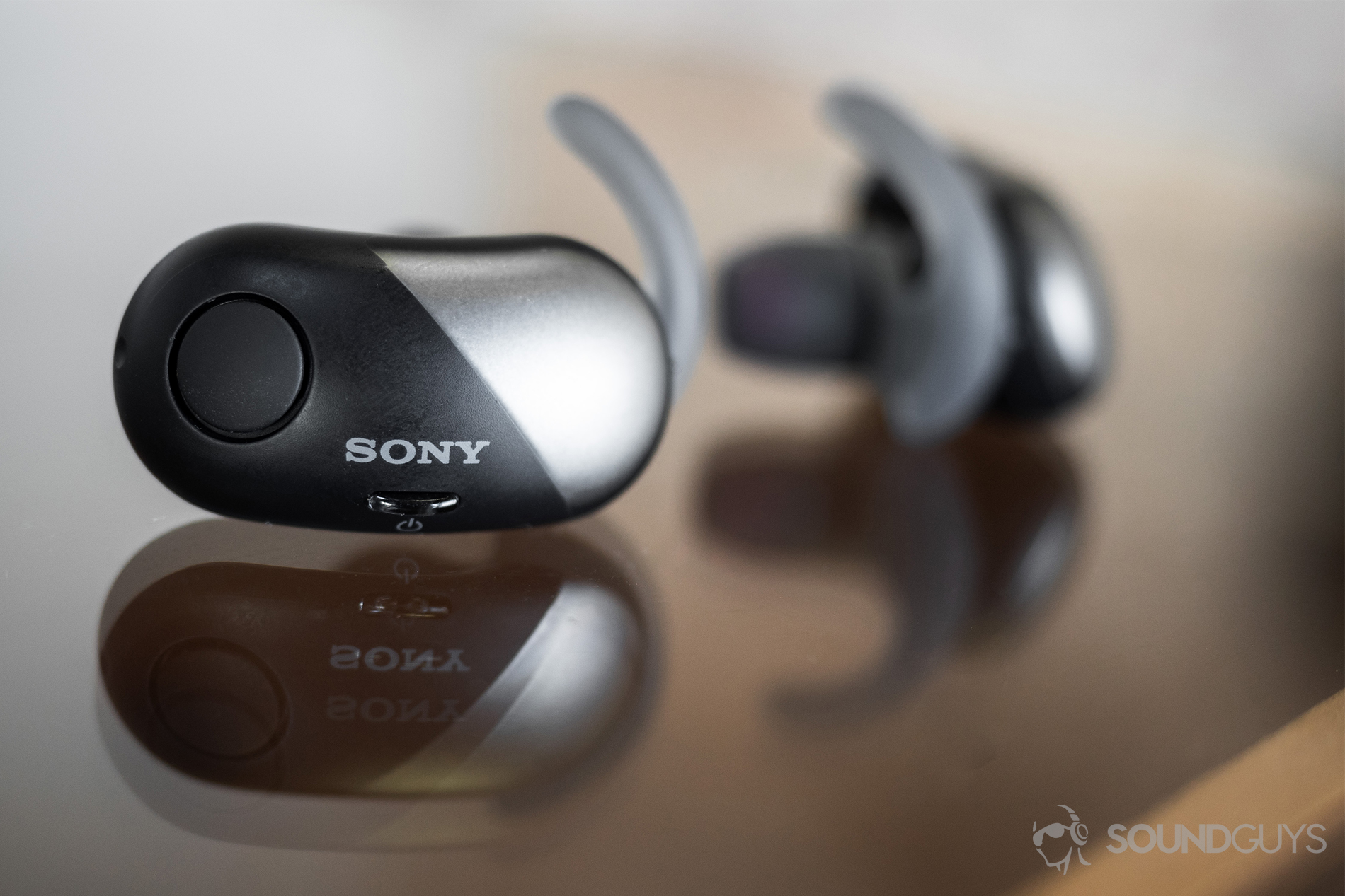 Sony WF-SP700N: The earbuds on a glass table