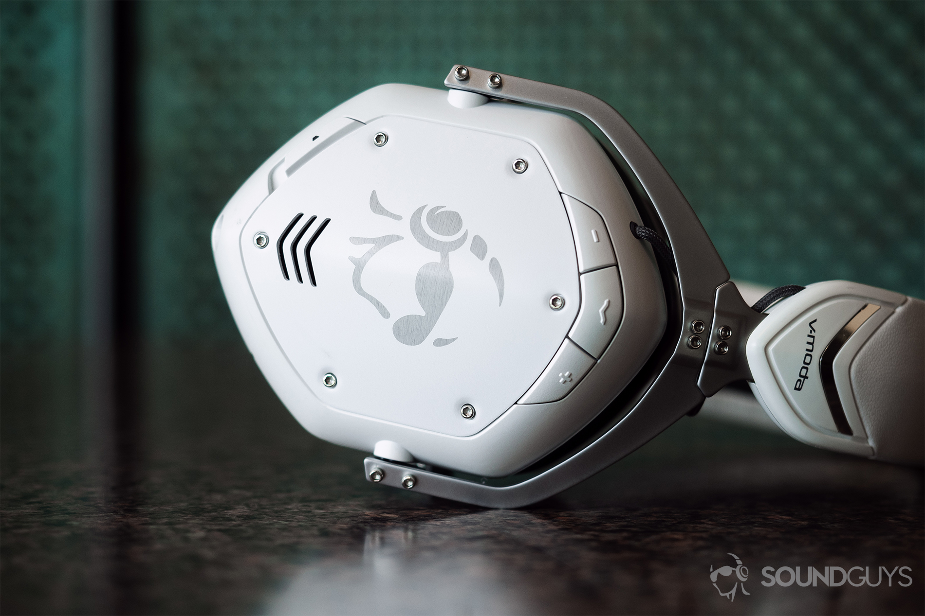 V-Moda_Crossfade 2 Codex-5 The V-Moda Crossfade 2 Codex right earcup laying horizontally on a table with a green background.