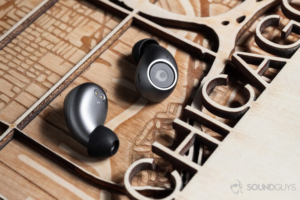 The earbuds alone on a lasercut wood piece of Chicago.