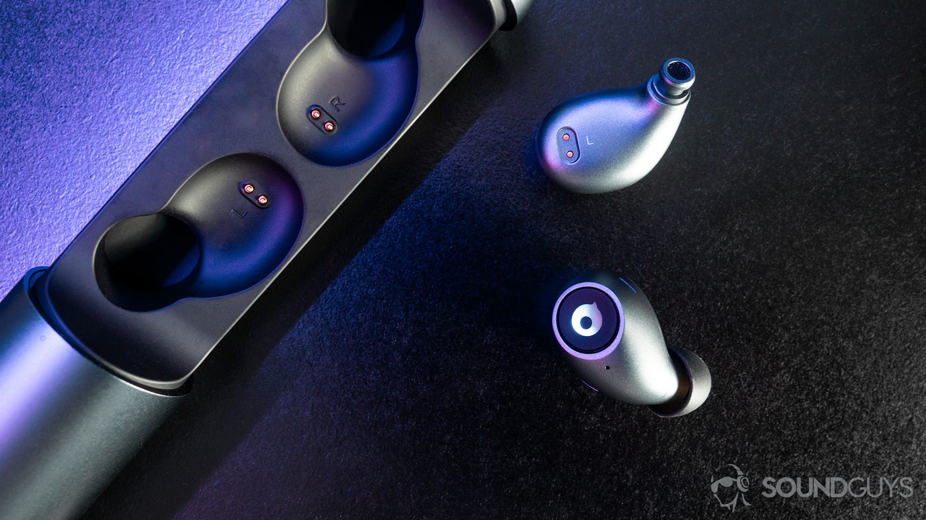 A top-down image of the earbuds with purple lighting on a black surface.