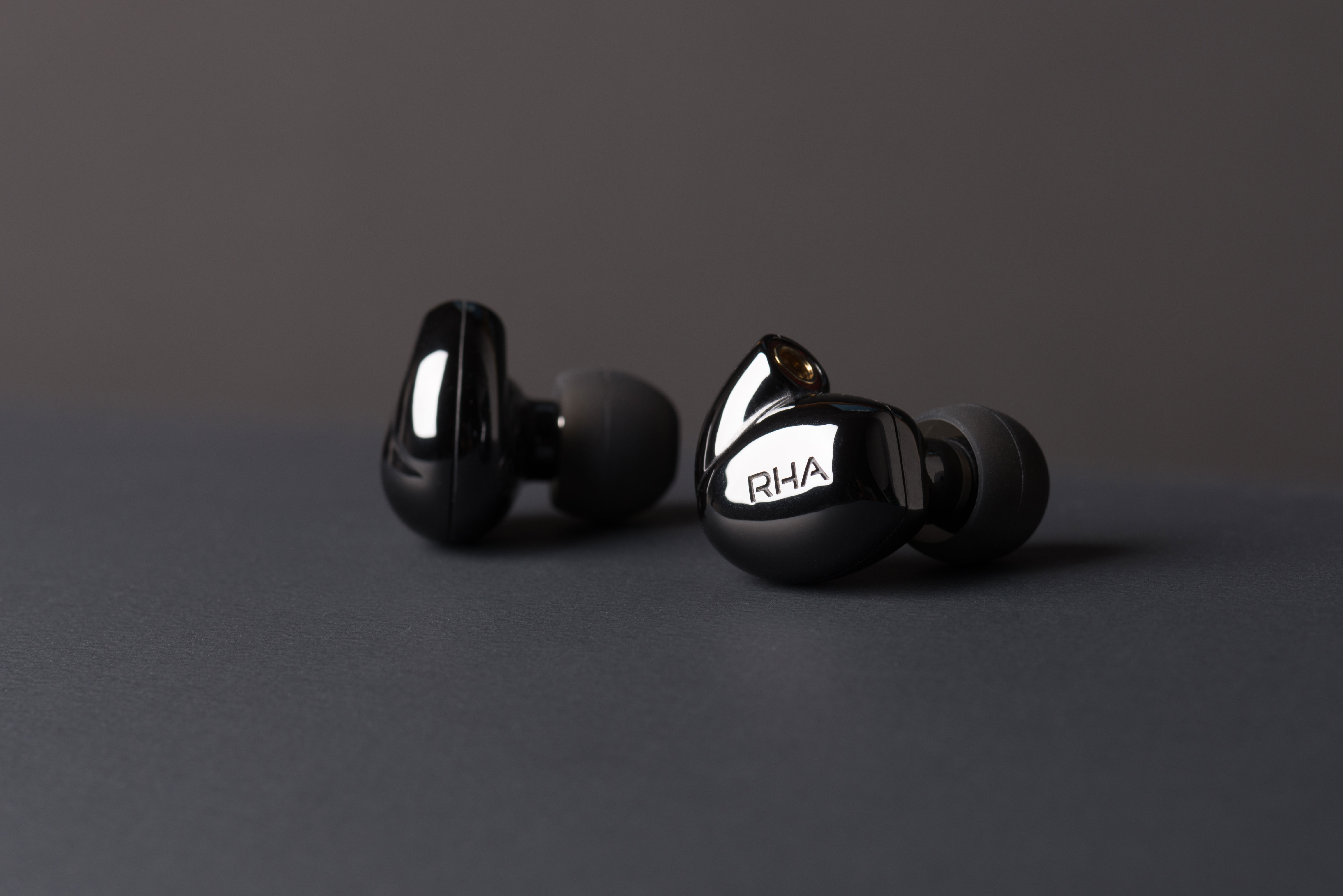 RHA CL2 Planar magnetic wireless earphones on grey background.