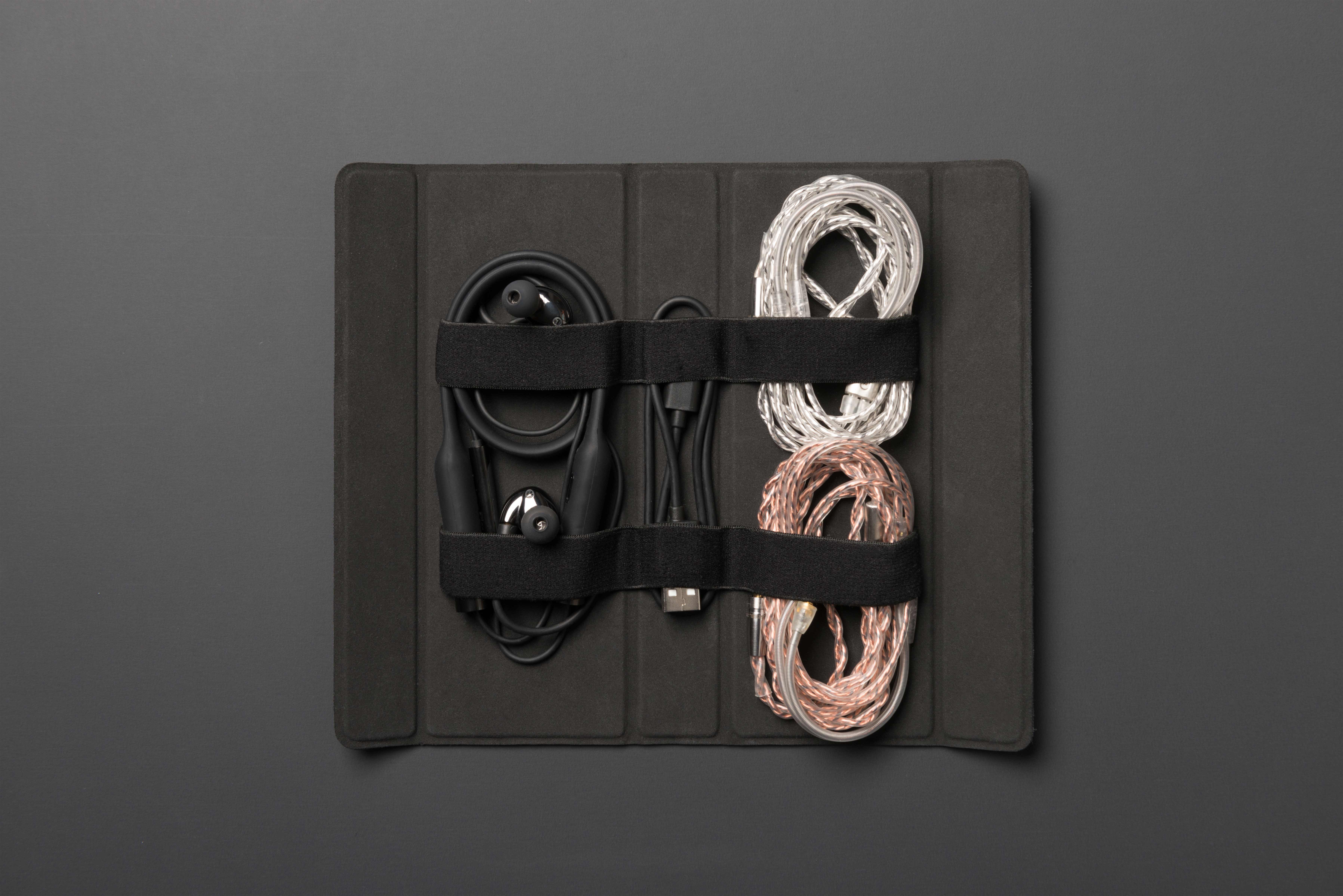 RHA CL2 Planar magnetic earphones with the accessories laid out in the carrying case on grey background.