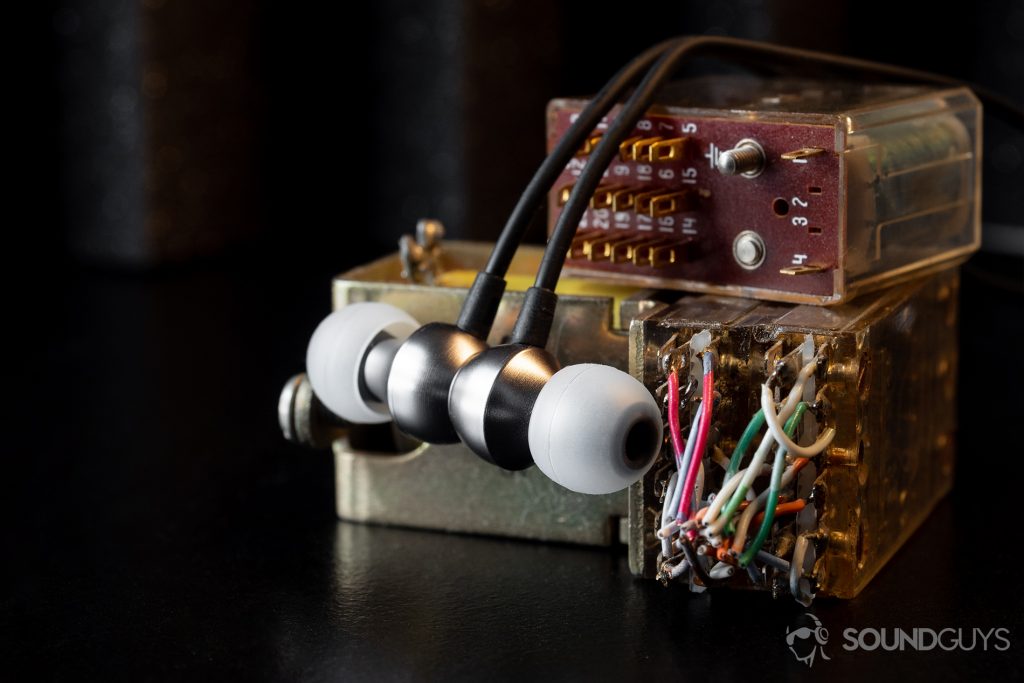 RHA MA390 Wireless: An image of the earbuds hung over small, electric, yellow-tinted blocks with protruding wires (green, white, red, yellow).