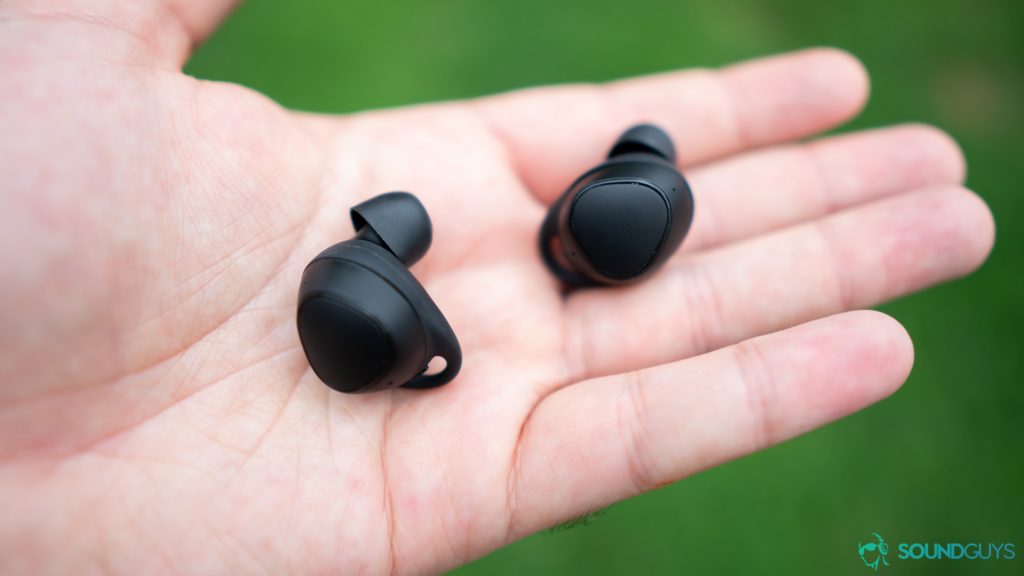 The Samsung Gear IconX held in the hand to show size.