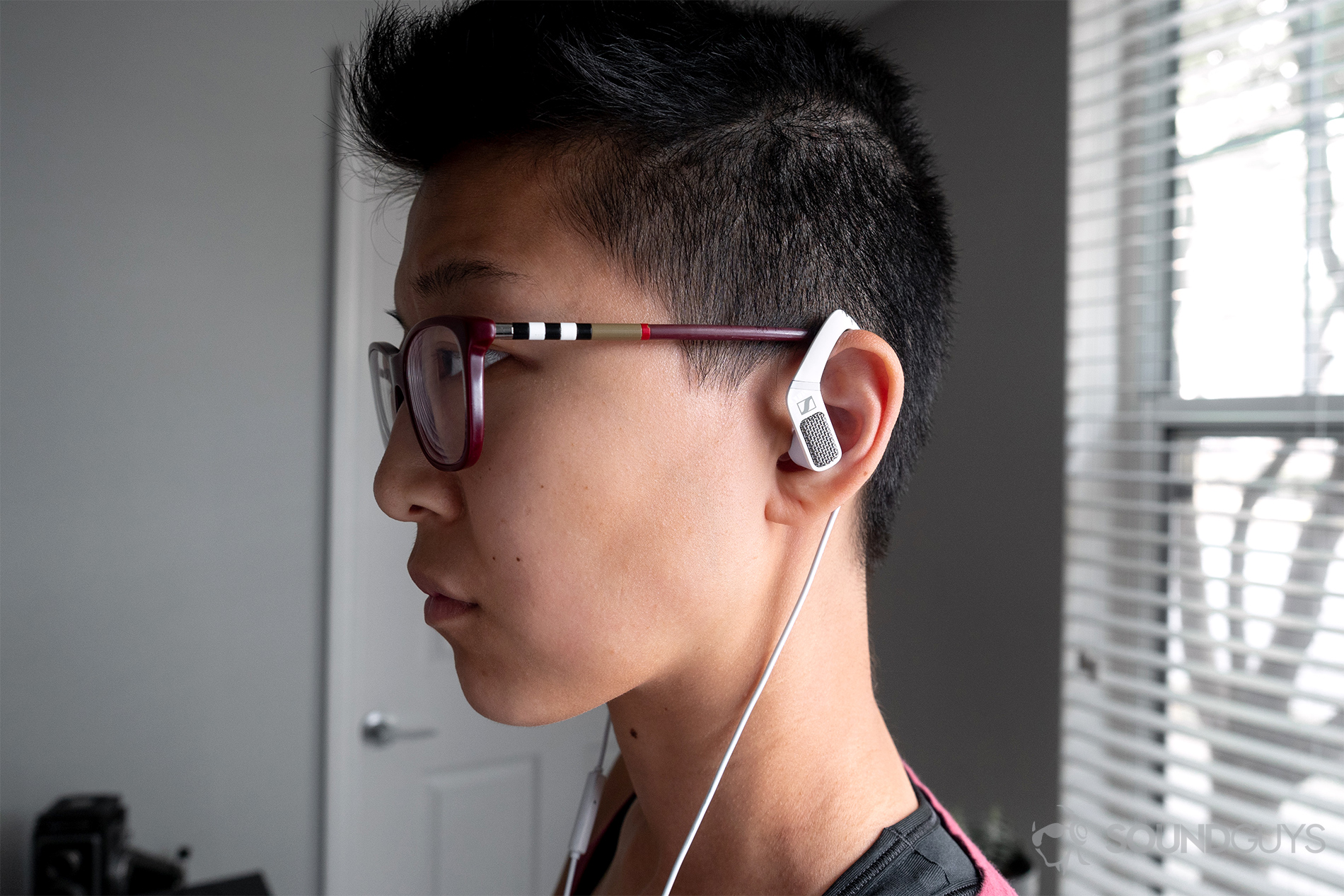 Sennheiser Ambeo Headset: Lily wearing the headset facing to the left. The wireless naturally fall down to the torso.