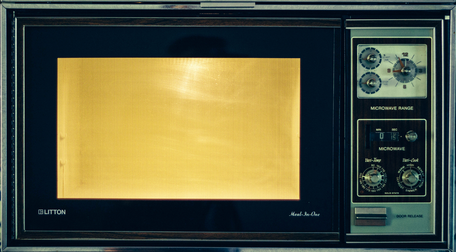 A photo of an old microwave oven in use.