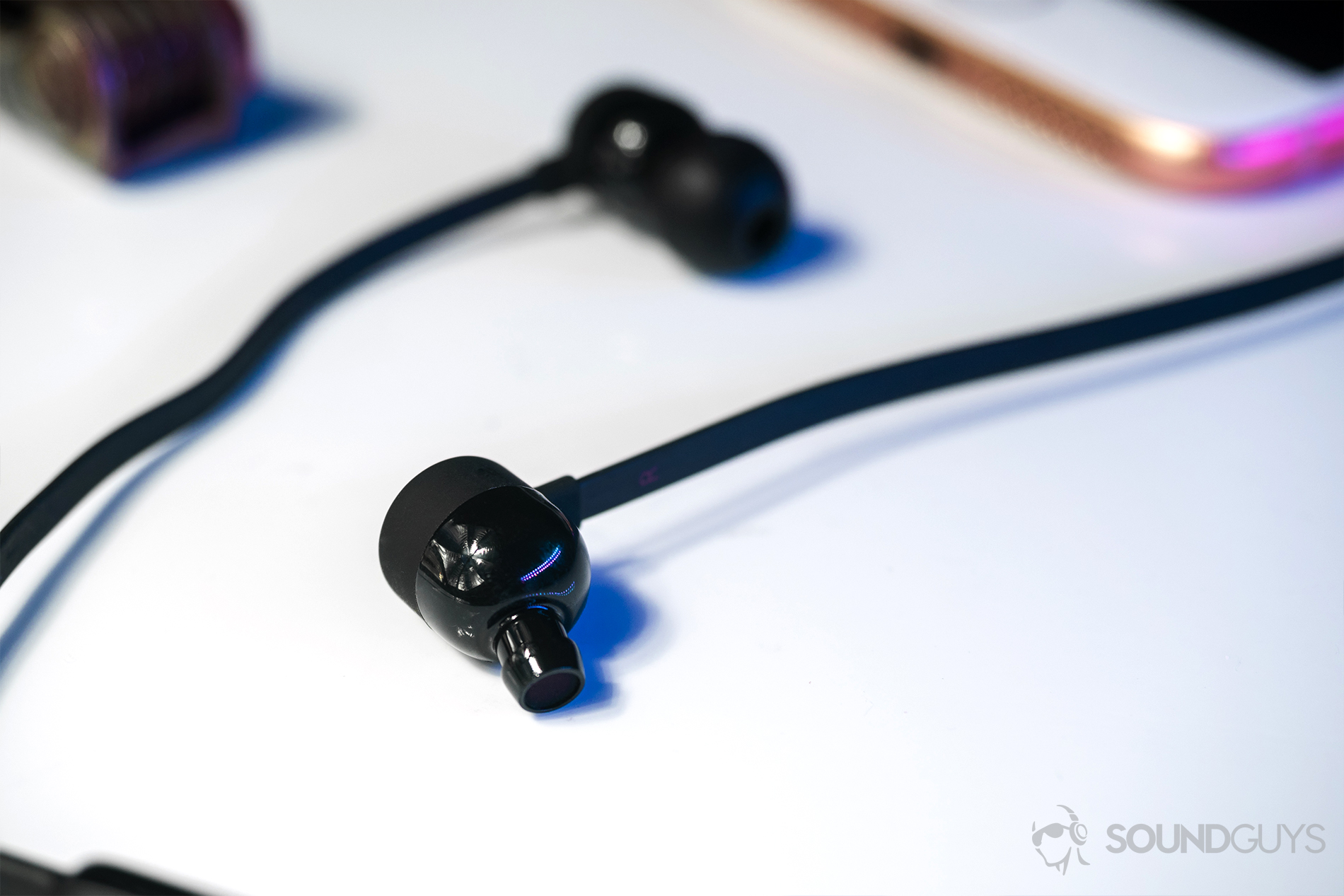 Beats_BeatsX-1 The angled nozzles of the BeatsX earbuds on a white surface.