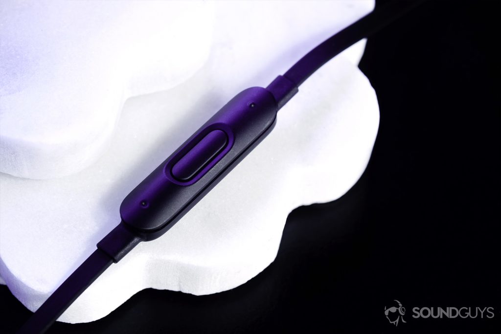 An photo of the BeatsX in-line control module on a set of overlapping white coasters on black table.