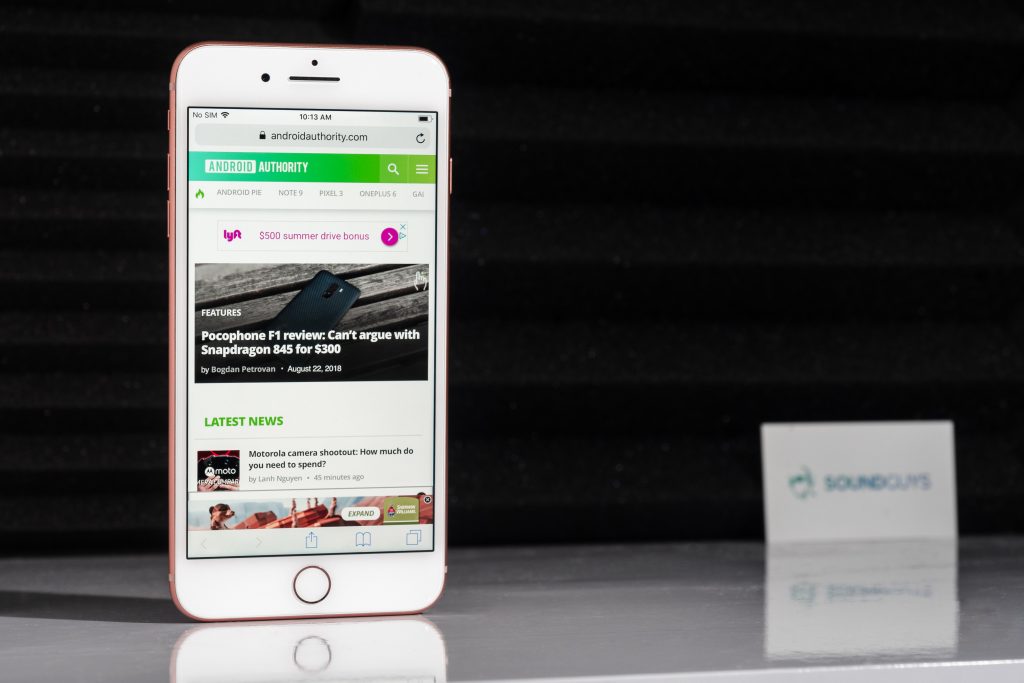 Beats alternatives: Image of an iPhone 8 Plus with Android Authority pulled up. The background consists of soundproofing and a SoundGuys business card.