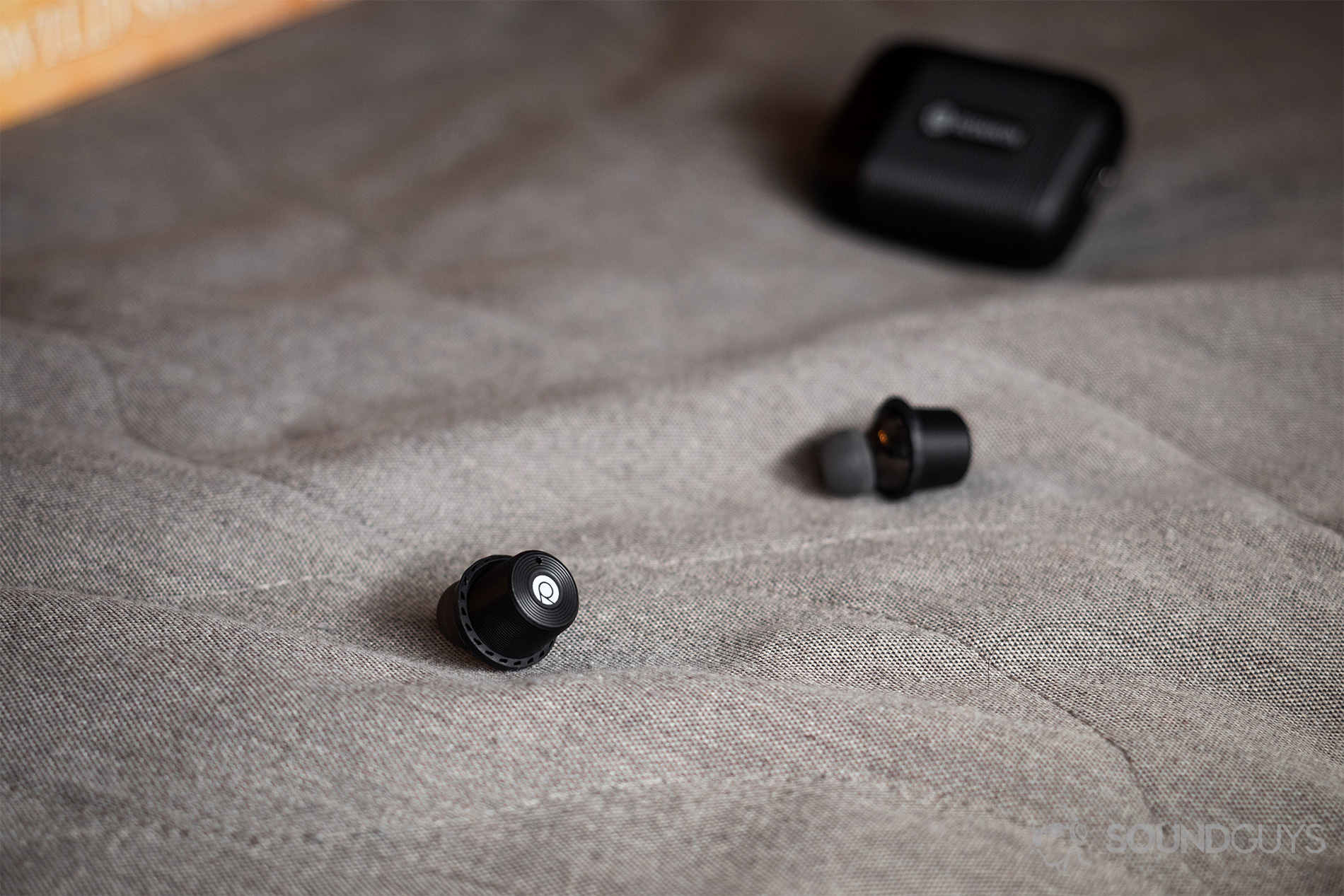 Rowkin Ascent Micro: The earbuds resting on a couch with the case in the background.