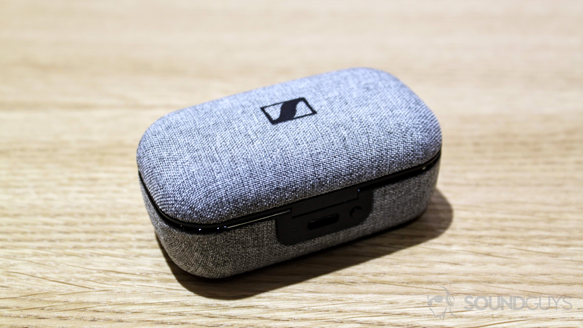 Sennheiser Momentum True Wireless earbuds case on a table.