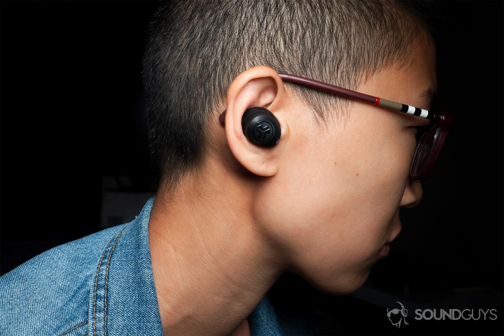 A picture of a woman wearing the JLab JBuds Air true wireless earbuds.