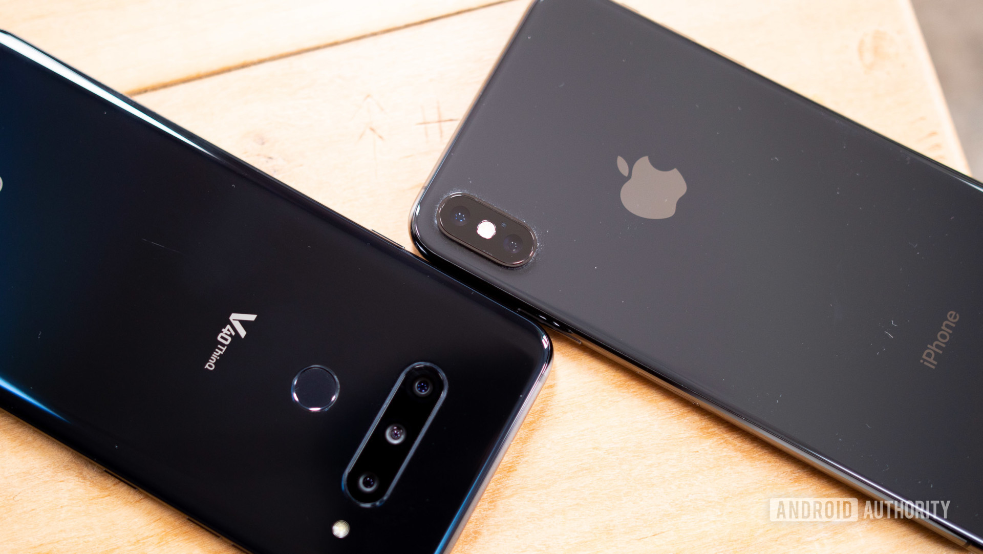 An aerial photo of an LG V40 ThinQ in black next to an Apple iPhone XS Max in space grey.
