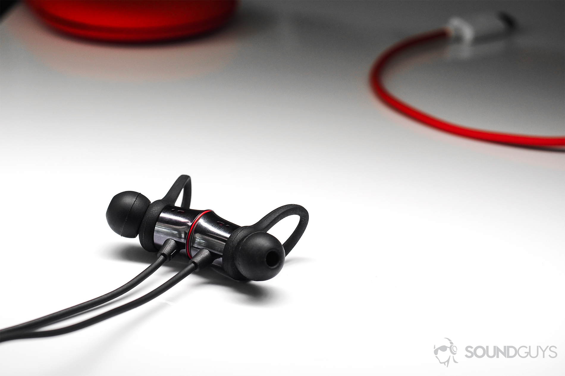 OnePlus_Bullets-6 An angled image of the OnePlus Bullets Wireless earbuds with part of the cable and case in the background.