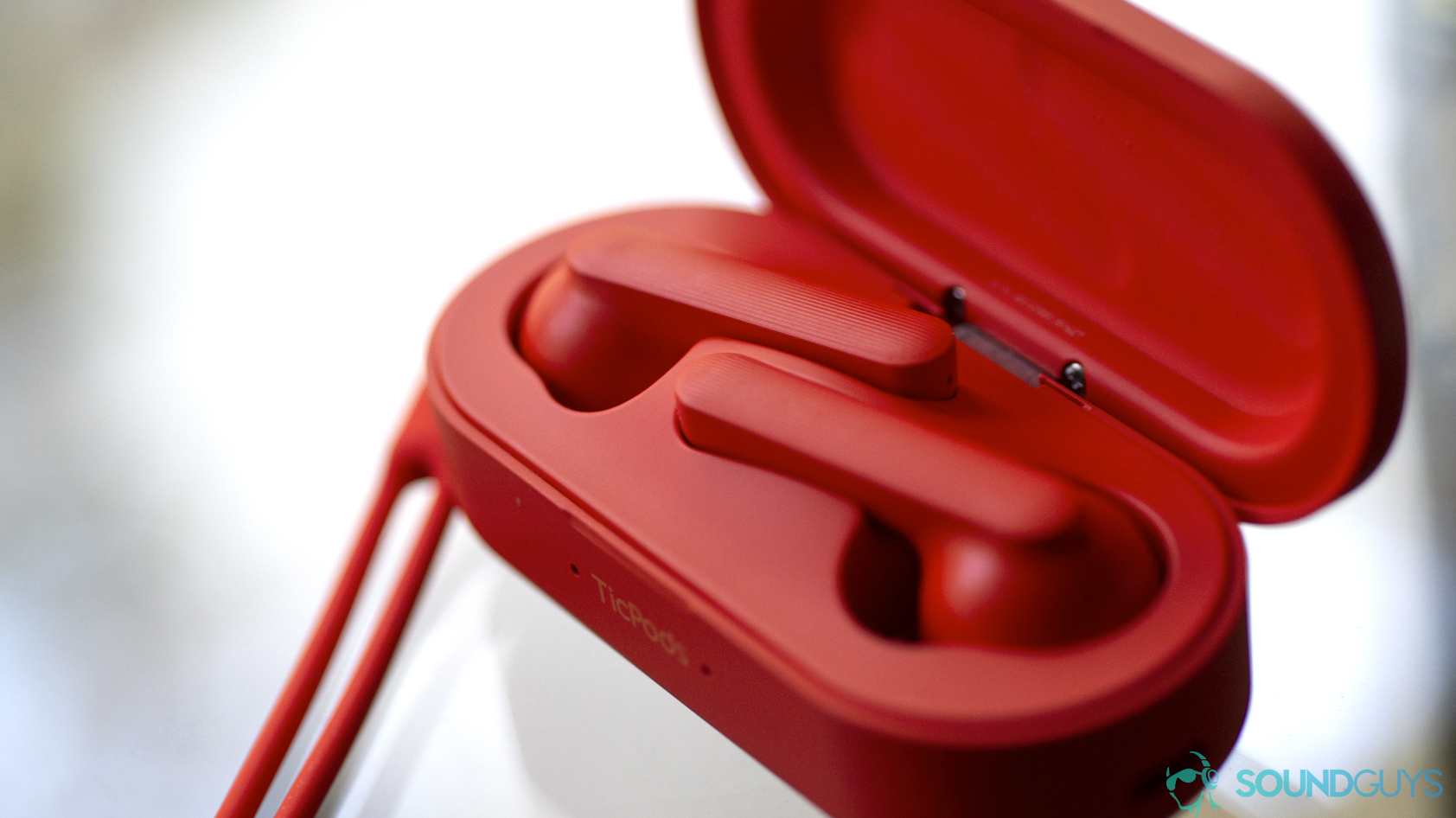 Mobvoi TicPods Free in red inside of its charging case against a white backdrop.