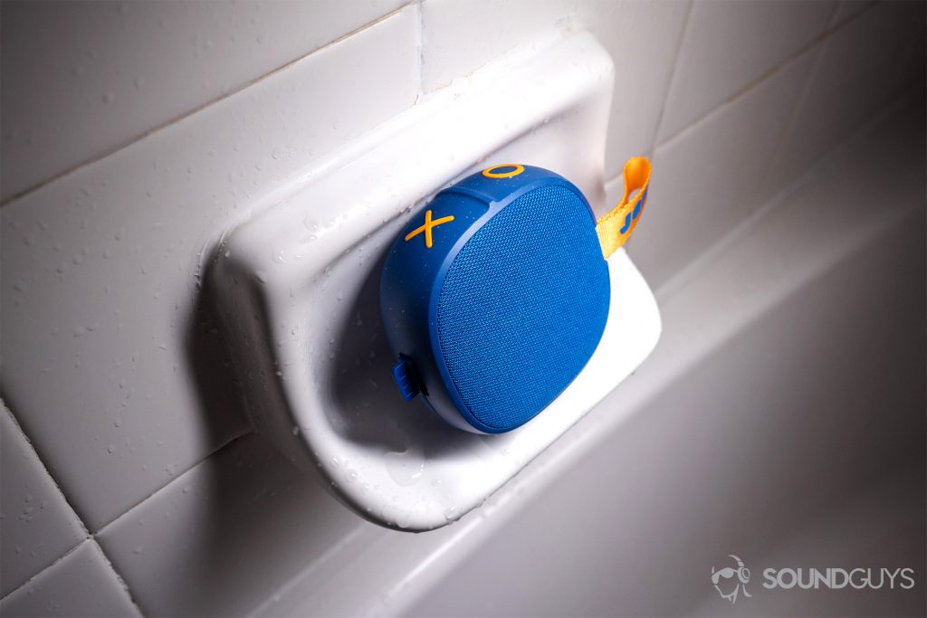 Jam Hang Up shower speaker: The speaker in blue on a soap holder against a shower wall.