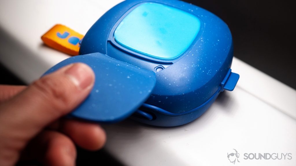 Best Bluetooth speakers under $100 - Jam Hang Up: A hand pulling back the flap to reveal the sticky pad on the back of the speaker.