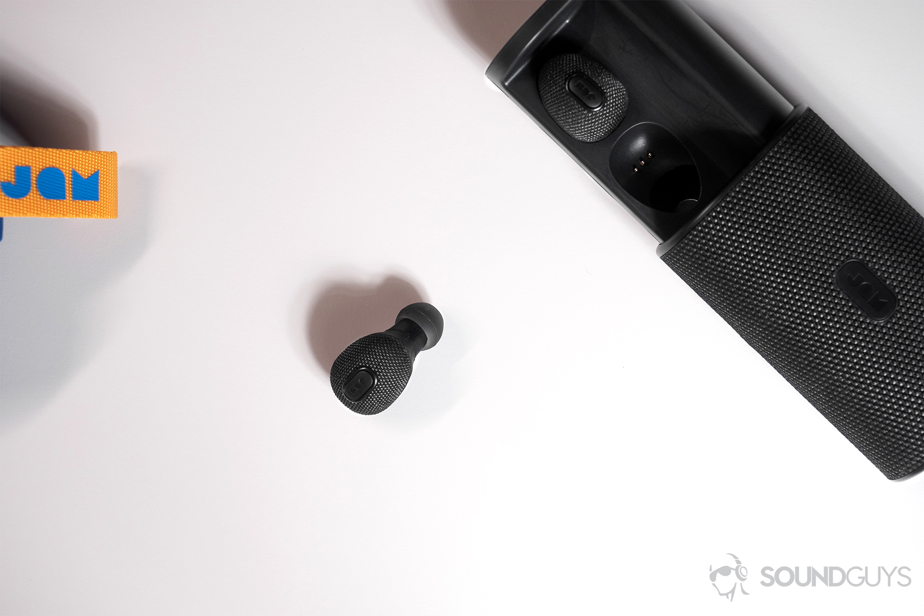 Jam Live True: Top-down image of the open charging case with one earbud on the table.