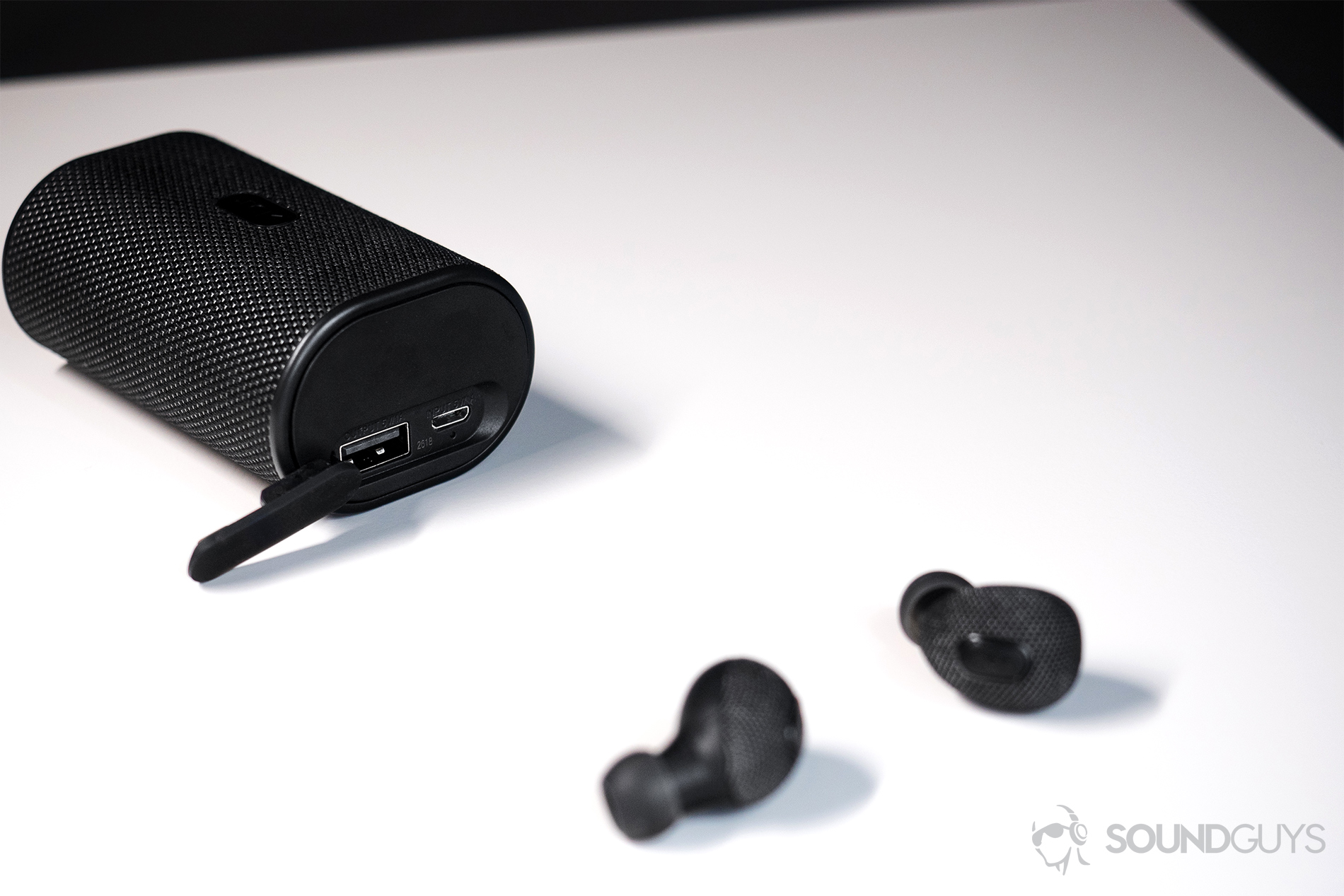 Jam Live True: The earbuds laid out in front of the case.