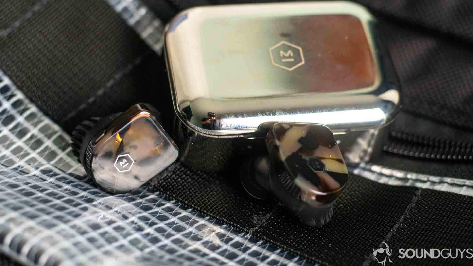 Master & Dynamic MW07-6 the Master & Dynamic MW07 earbuds and the case on a bag.