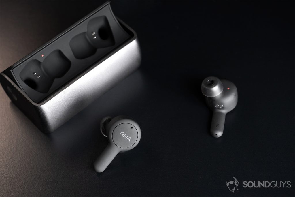 RHA TrueConnect open charging case with the earbuds facing the lens in different directions; the closer 'bud shows the RHA logo.