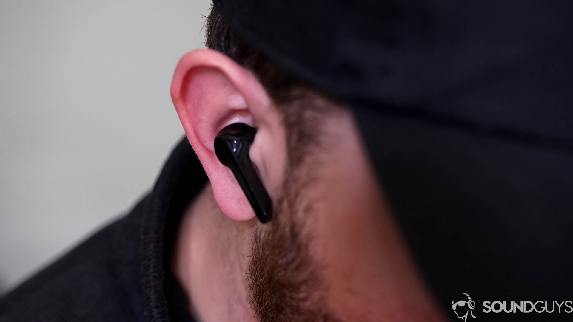 Pictured is a man wearing the black Anker Soundcore Liberty Air with a black hat. 