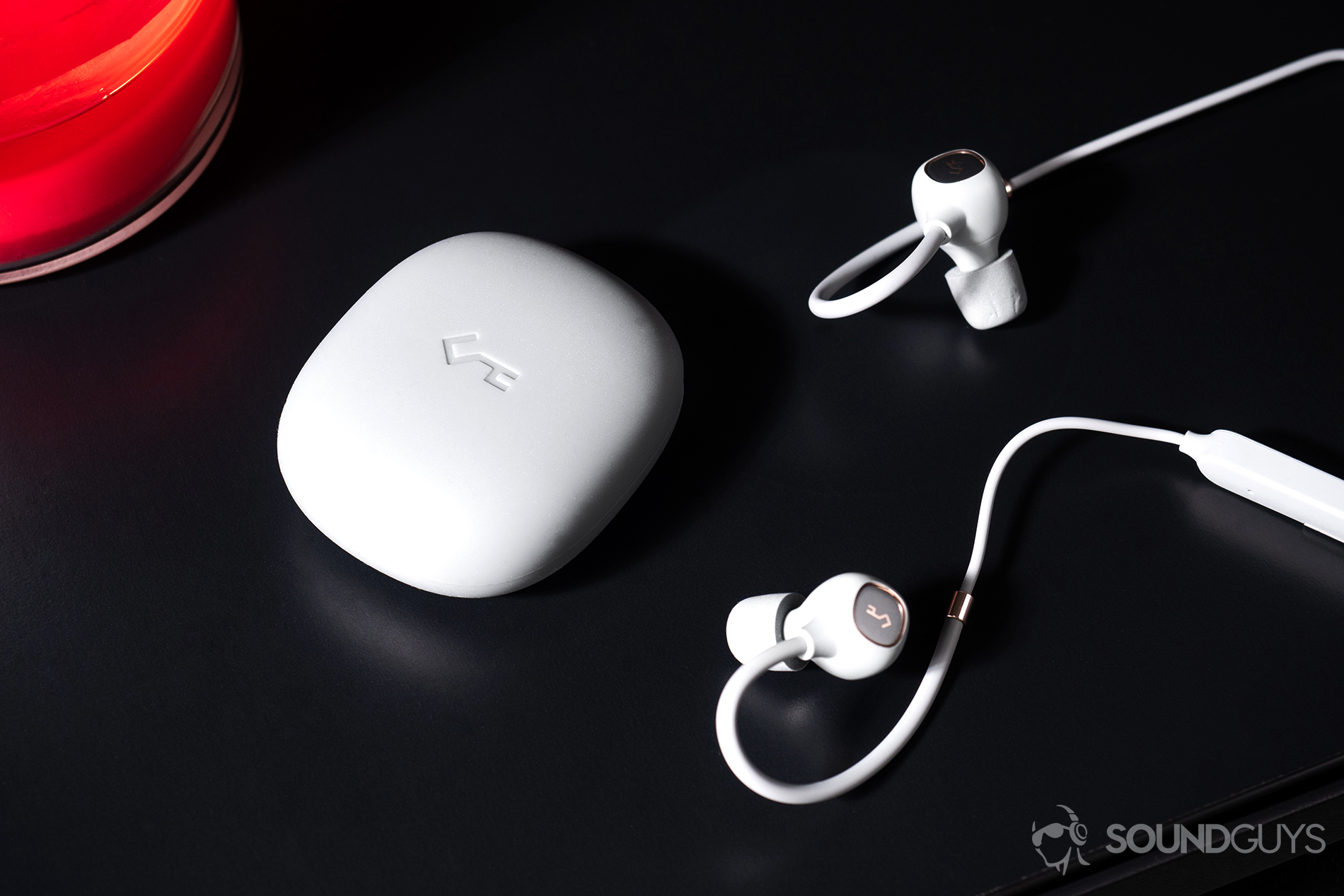 Aukey_EP-B80-5 Aukey EP-B80: Downward angled image of the included silicone carrying case and the earbuds entering the frame from the right.