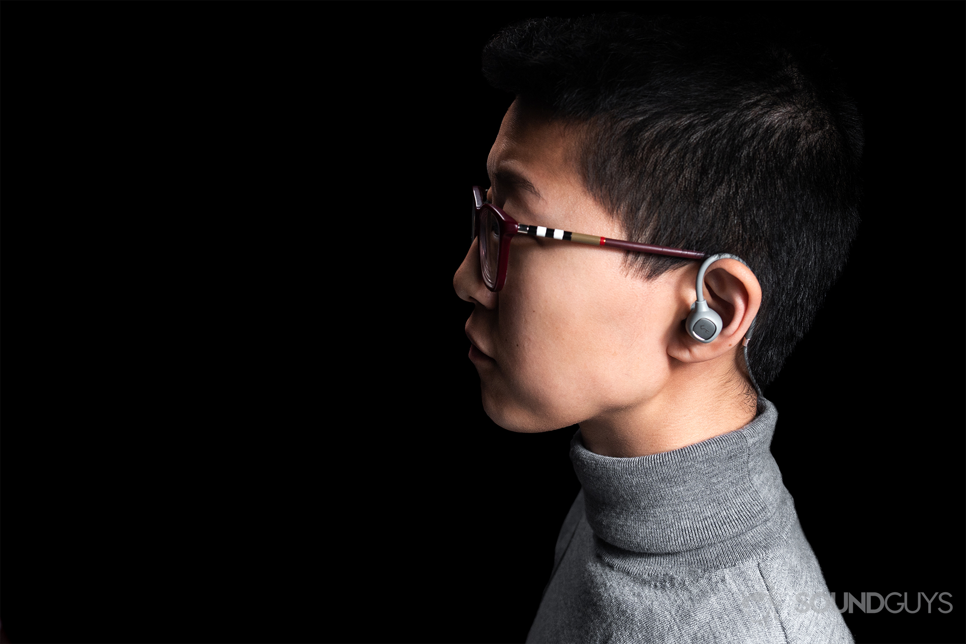 Aukey EP-B80: A woman wearing the Aukey EP-B80 wireless earbuds against a black background.