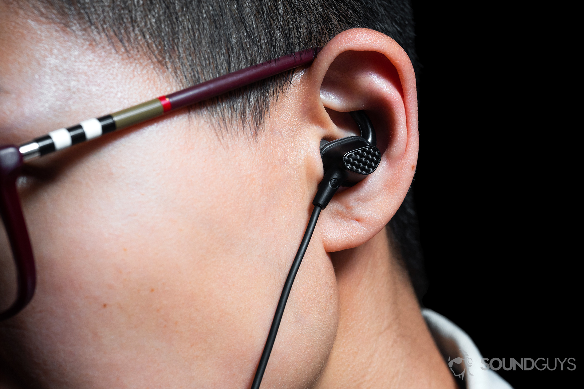 A woman wearing the earbuds with a close-up of the ear to depict the fit.