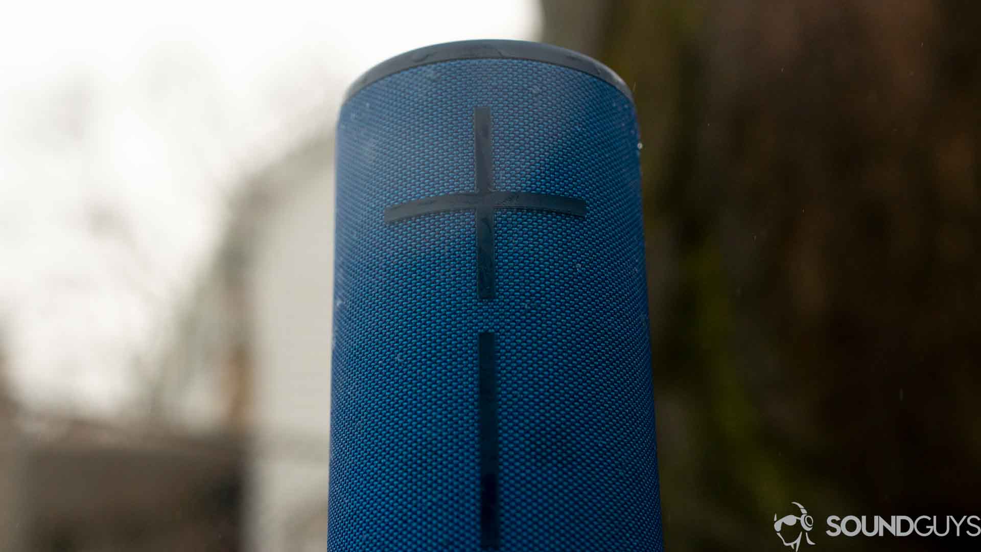 The UE Boom 3 Bluetooth speaker in blue against a wood and white background.