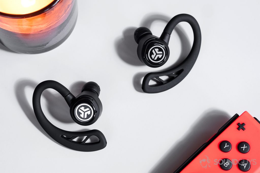 JLab Epic Air Elite: Top-down image of the earbuds with a Nintendo Switch controller in the bottom right corner of the image.