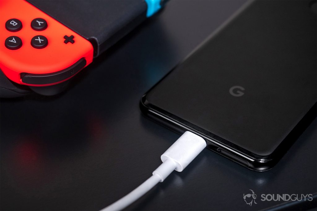 USB-C, headphone jack: Google Pixel 3 with USB-C headphones connected and Nintendo Switch controller in top left corner of image.
