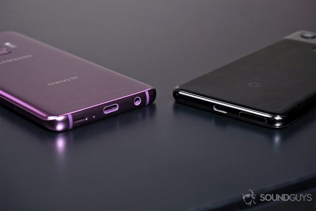 A picture of the Samsung S9 lilac and Google Pixel 3 with bases showing to reveal headphone jack and lack thereof.