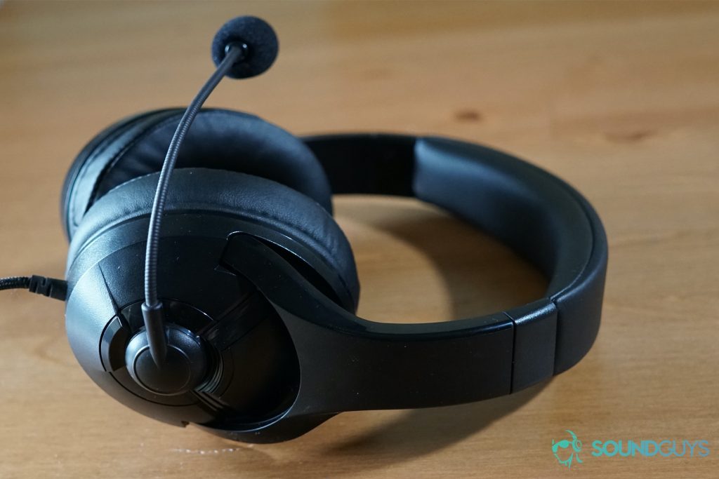 The AmazonBasics USB Gaming Headset sits on a wood table, its mic bent forward.
