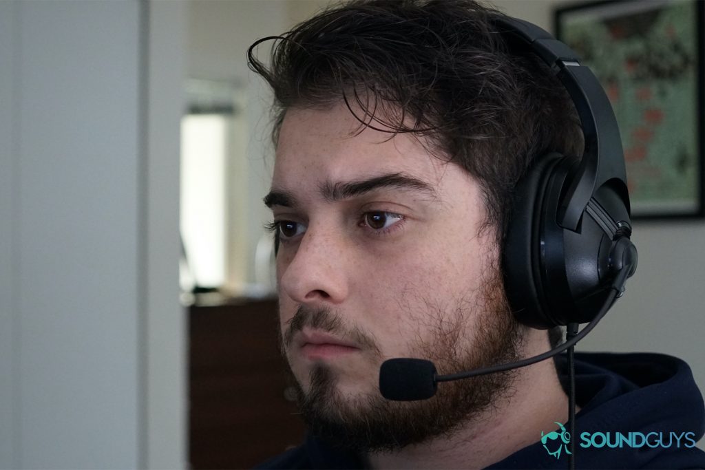 A man wearing the AmazonBasics USB Gaming Headset sits at a computer.