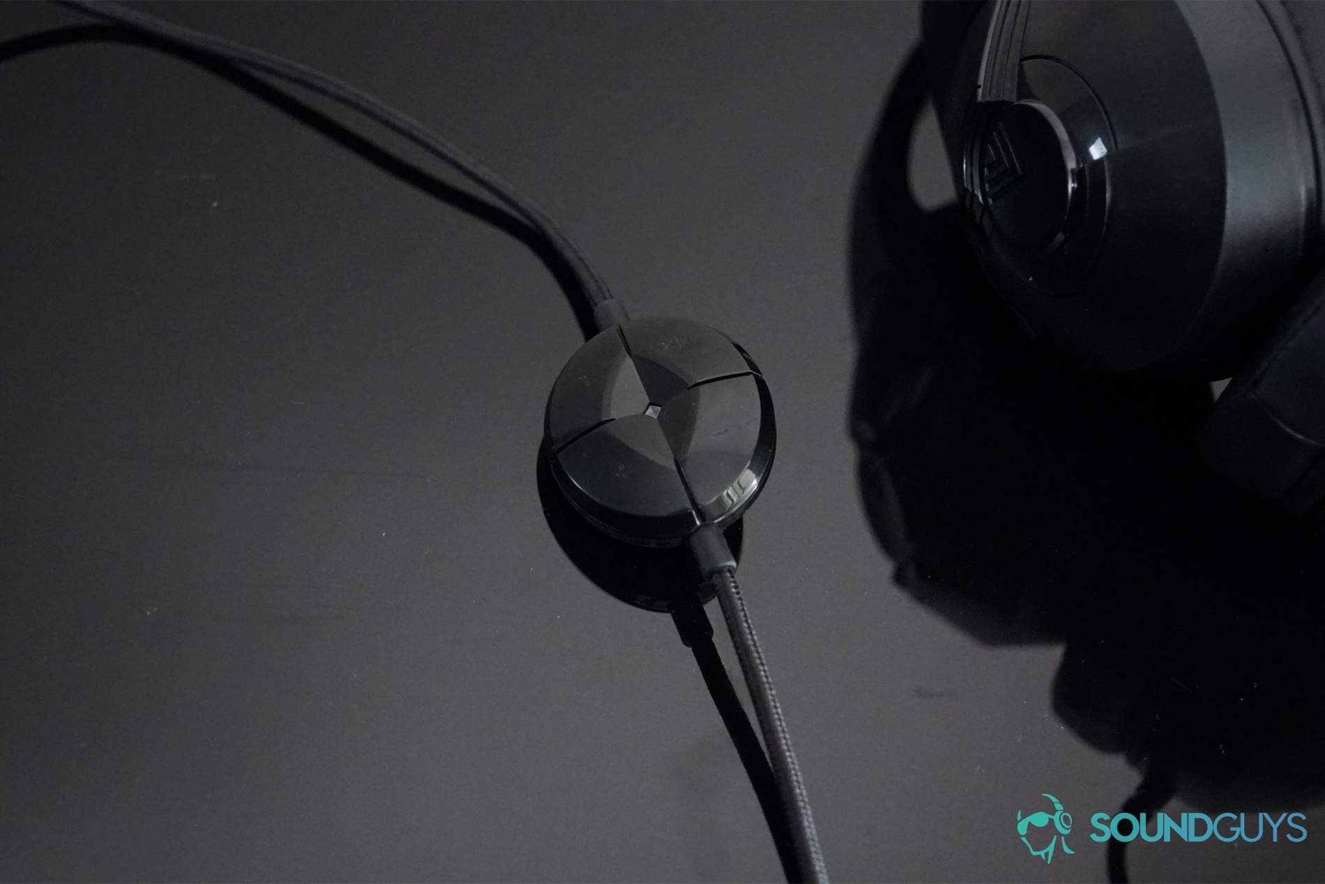 The AmazonBasics USB Gaming headset sits next to its inline controls on a reflective black surface.