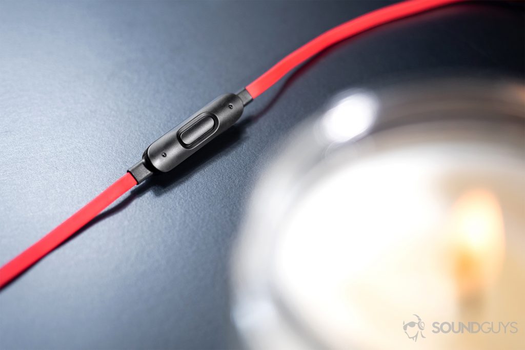 Beats urBeats3: Image of the integrated remote and microphone with a candle in the bottom right corner of the image.
