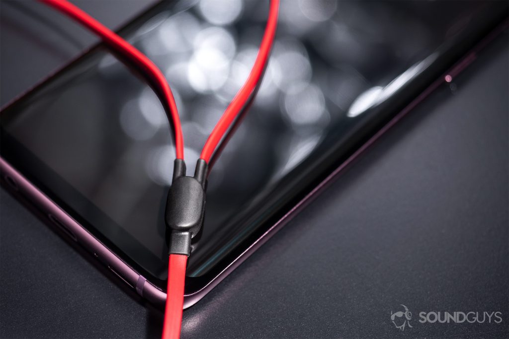 Beats urBeats3: The Y-splitter where the cable diverges resting atop a Samsung Galaxy S9.