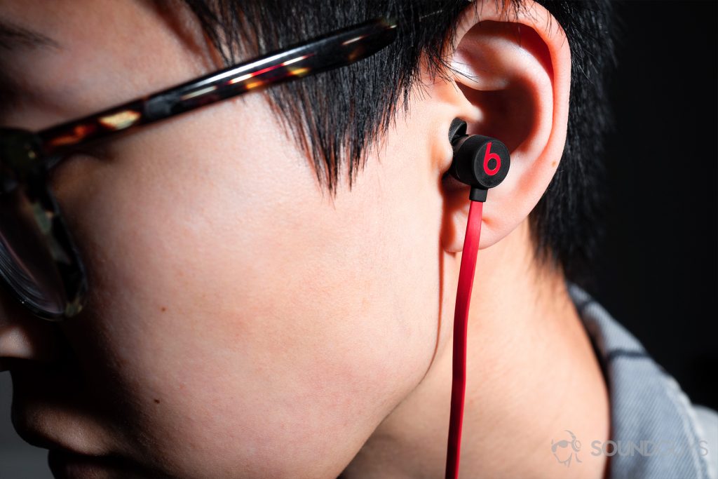 Headphone stand - Beats urBeats3: A woman looking off to the side while wearing the earbuds.