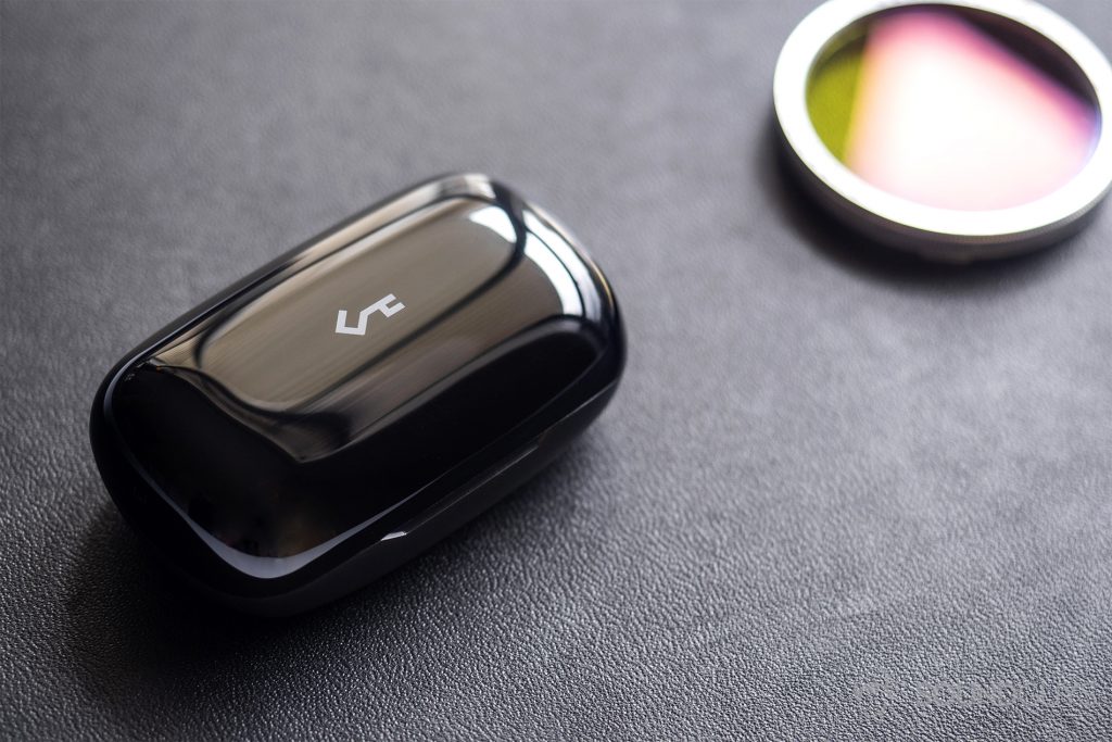 Aukey EP-T16 review: An angled image of the charging case, closed, on a black leatherette surface.